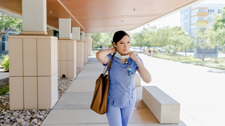 nurse with bag walking outside
