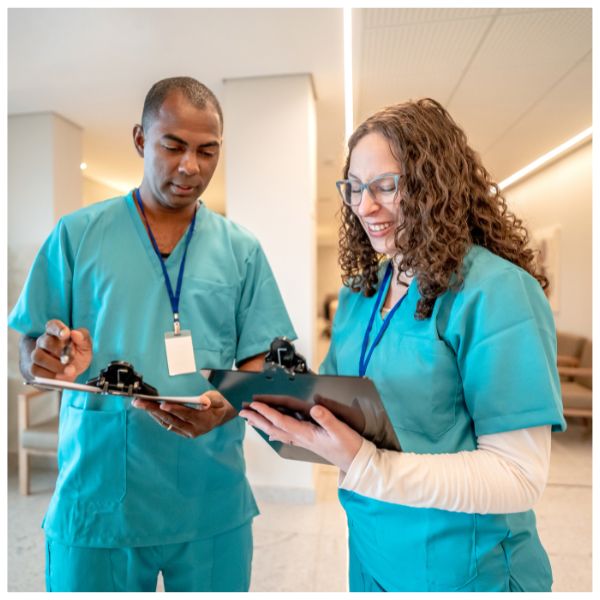 two nurses talking together, going over a chart