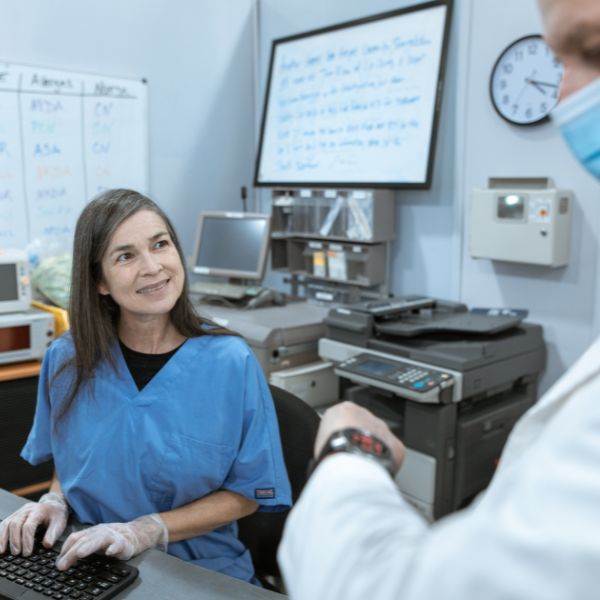 healthcare worker smiling and talking with a doctor